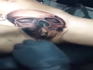 Elle se fait tatouer une tête de mort sur la chatte